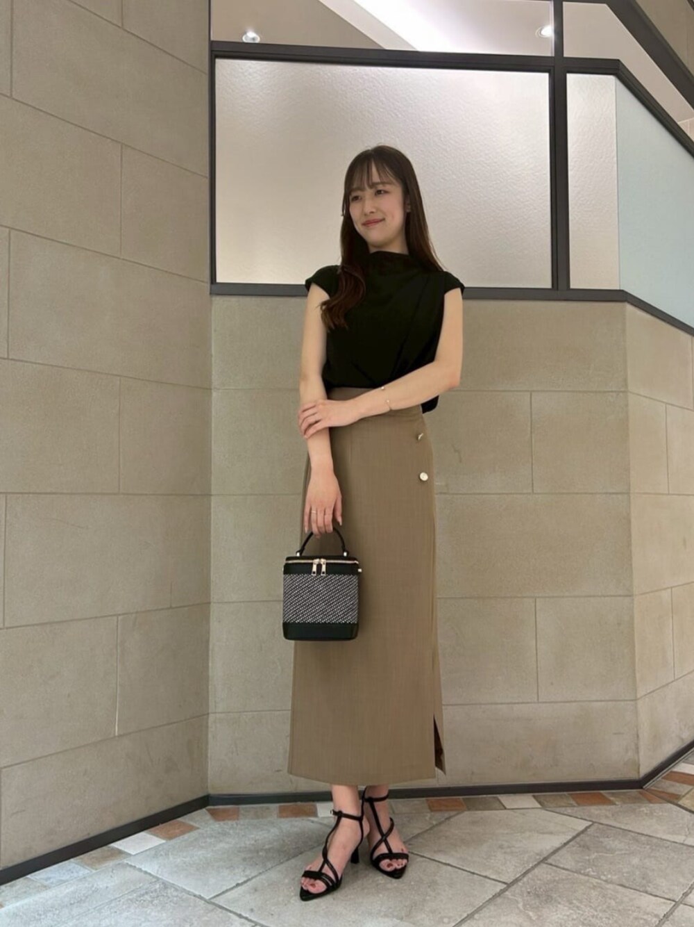 ブラック系のパンプス、ブラック系のショルダーバッグ、ブラック系のシャツ/ブラウスを着用したレディースの夏コーディネートの1枚目の写真