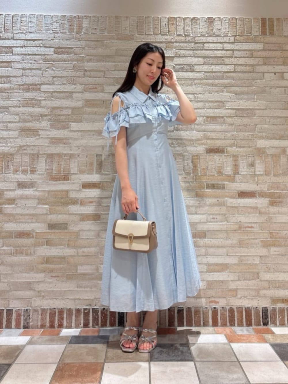 グレー系のショルダーバッグ、シルバー系のパンプス、ブルー系のワンピースを着用したレディースの夏コーディネートの1枚目の写真