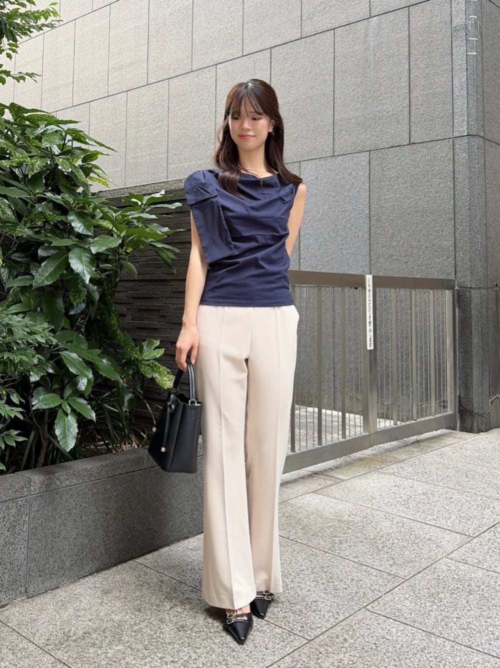 ブラック系のパンプス、ブラック系のショルダーバッグ、ブルー系のTシャツ/カットソーを着用したレディースの夏コーディネートの1枚目の写真