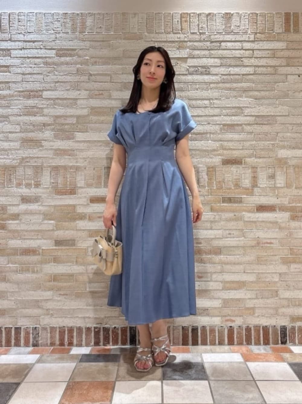 シルバー系のパンプス、ホワイト系のショルダーバッグ、ブルー系のワンピースを着用したレディースの夏コーディネートの1枚目の写真