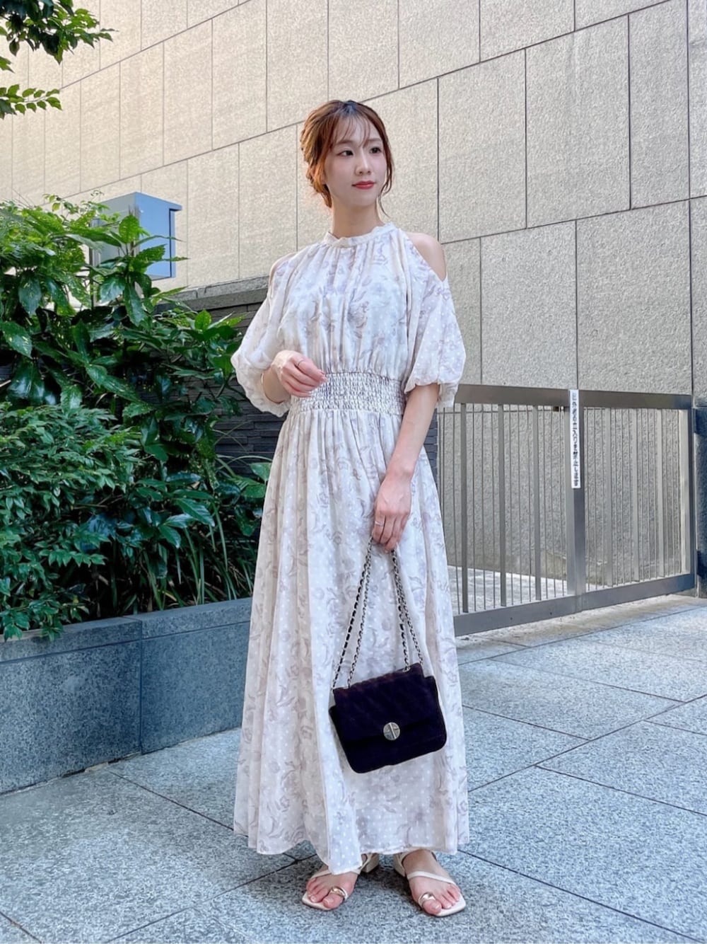 ブラウン系のショルダーバッグ、ホワイト系のパンプス、ホワイト系のワンピースを着用したレディースの夏コーディネートの1枚目の写真