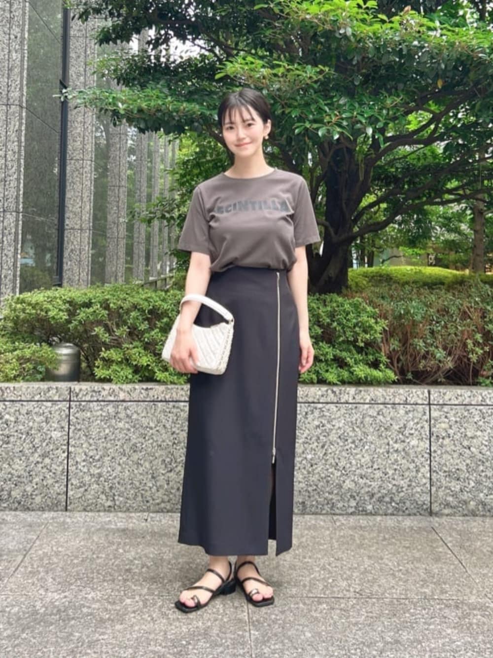 グレー系のTシャツ/カットソー、ブラック系のスカートを着用したレディースの秋コーディネートの1枚目の写真