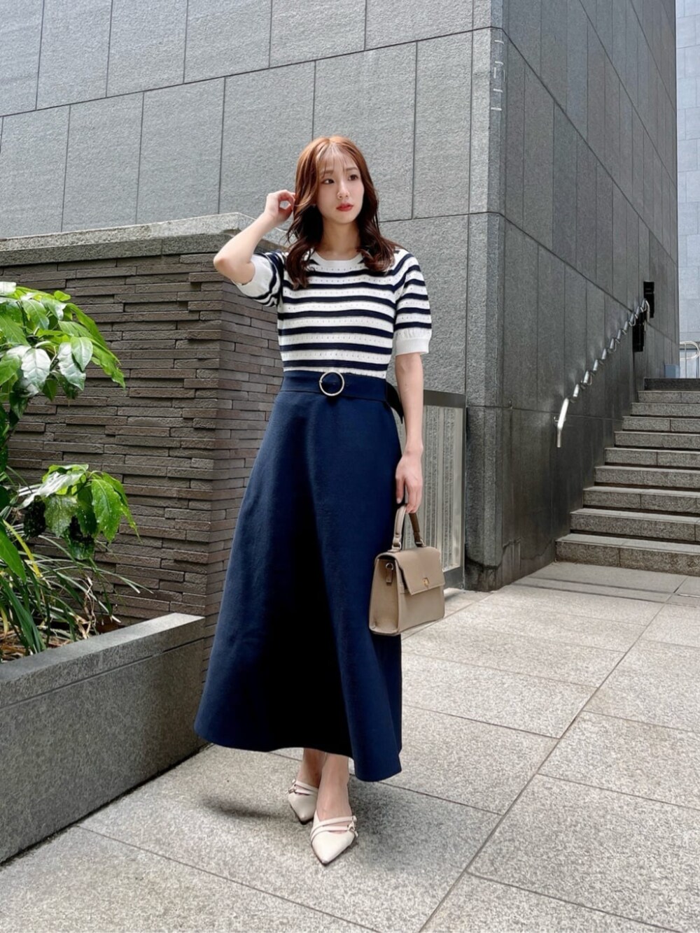 ブルー系のワンピース、ブラウン系のショルダーバッグを着用したレディースの春コーディネートの1枚目の写真