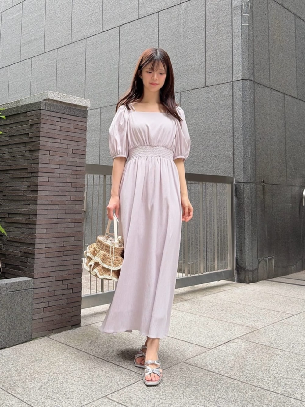 シルバー系のパンプス、ベージュ系のショルダーバッグ、ピンク系のワンピースを着用したレディースの春コーディネートの1枚目の写真