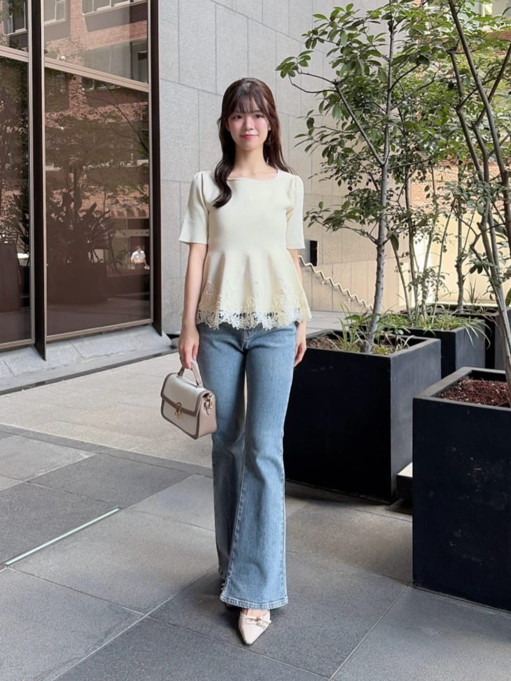 ベージュ系のパンプス、グレー系のショルダーバッグ、ホワイト系のニット/セーターを着用したレディースの夏コーディネートの1枚目の写真