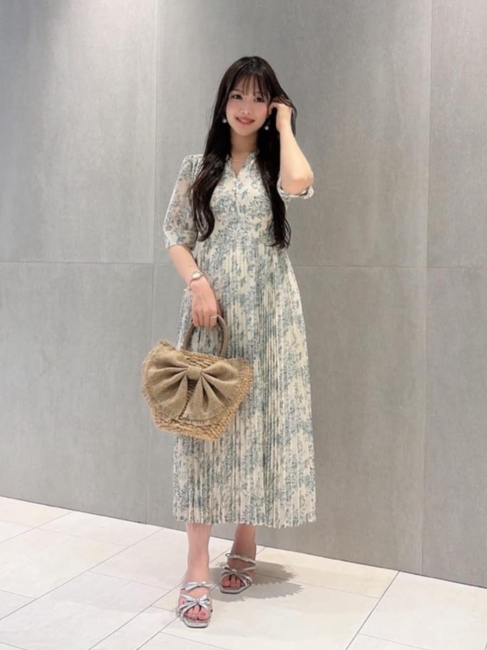 シルバー系のパンプス、ホワイト系のワンピース、ベージュ系のショルダーバッグを着用したレディースの夏コーディネートの1枚目の写真
