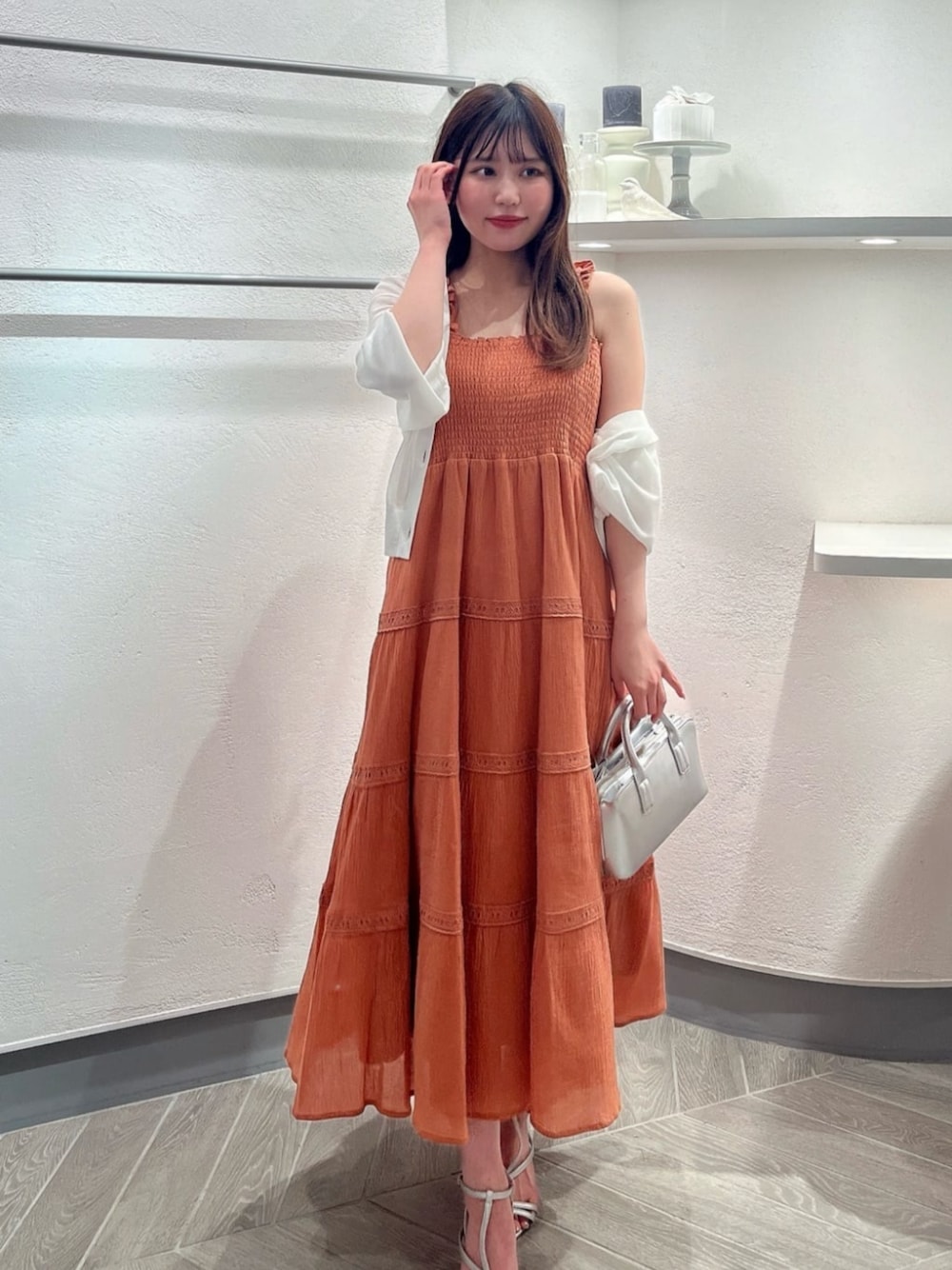 シルバー系のパンプス、ホワイト系のカーディガン/ボレロ、シルバー系のトートバッグを着用したレディースの夏コーディネートの1枚目の写真