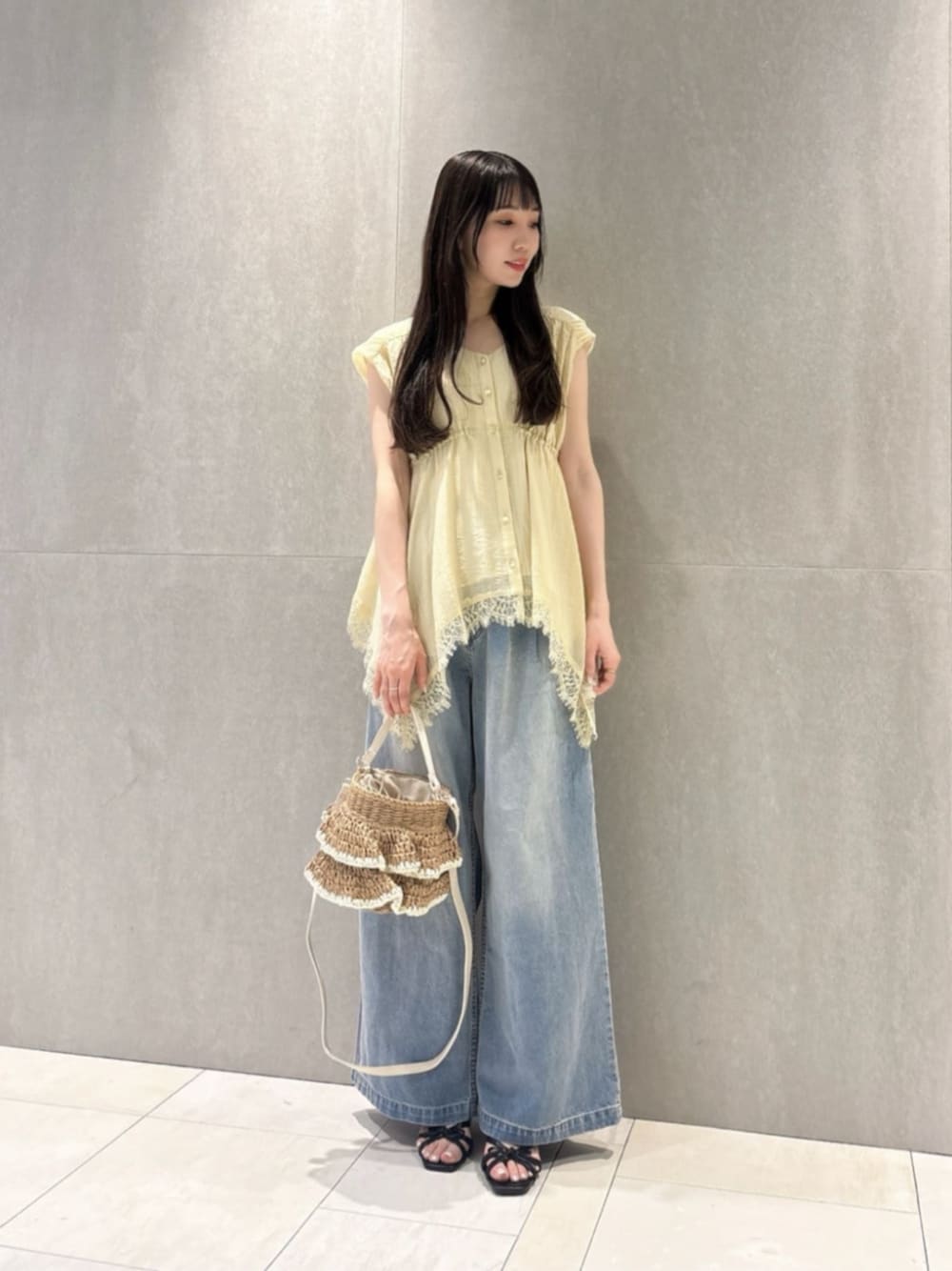 イエロー系のシャツ/ブラウス、ブルー系のその他パンツ、ベージュ系のショルダーバッグを着用したレディースの春コーディネートの1枚目の写真