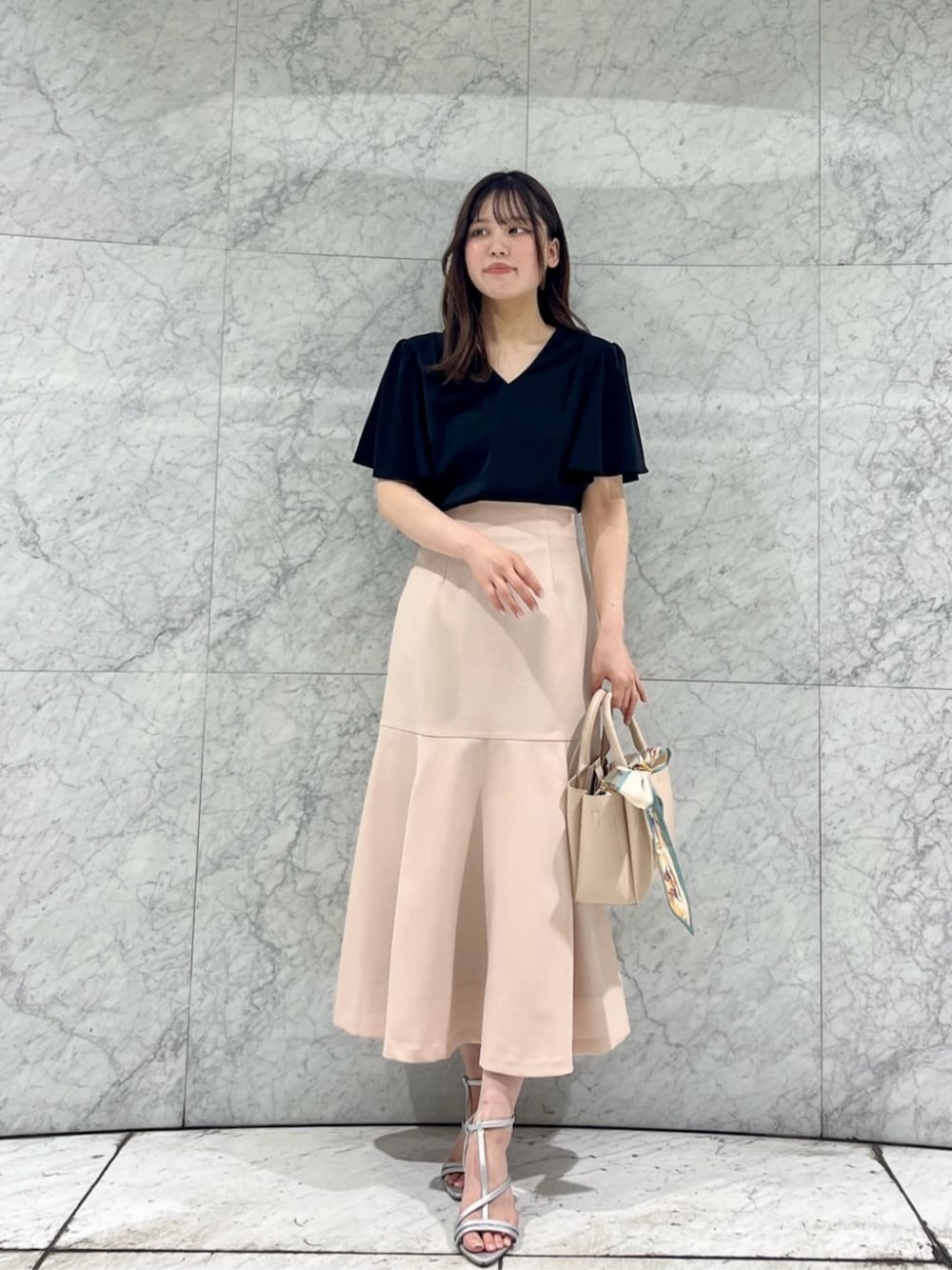 シルバー系のパンプス、ブラック系のシャツ/ブラウス、ピンク系のスカートを着用したレディースの春コーディネートの1枚目の写真