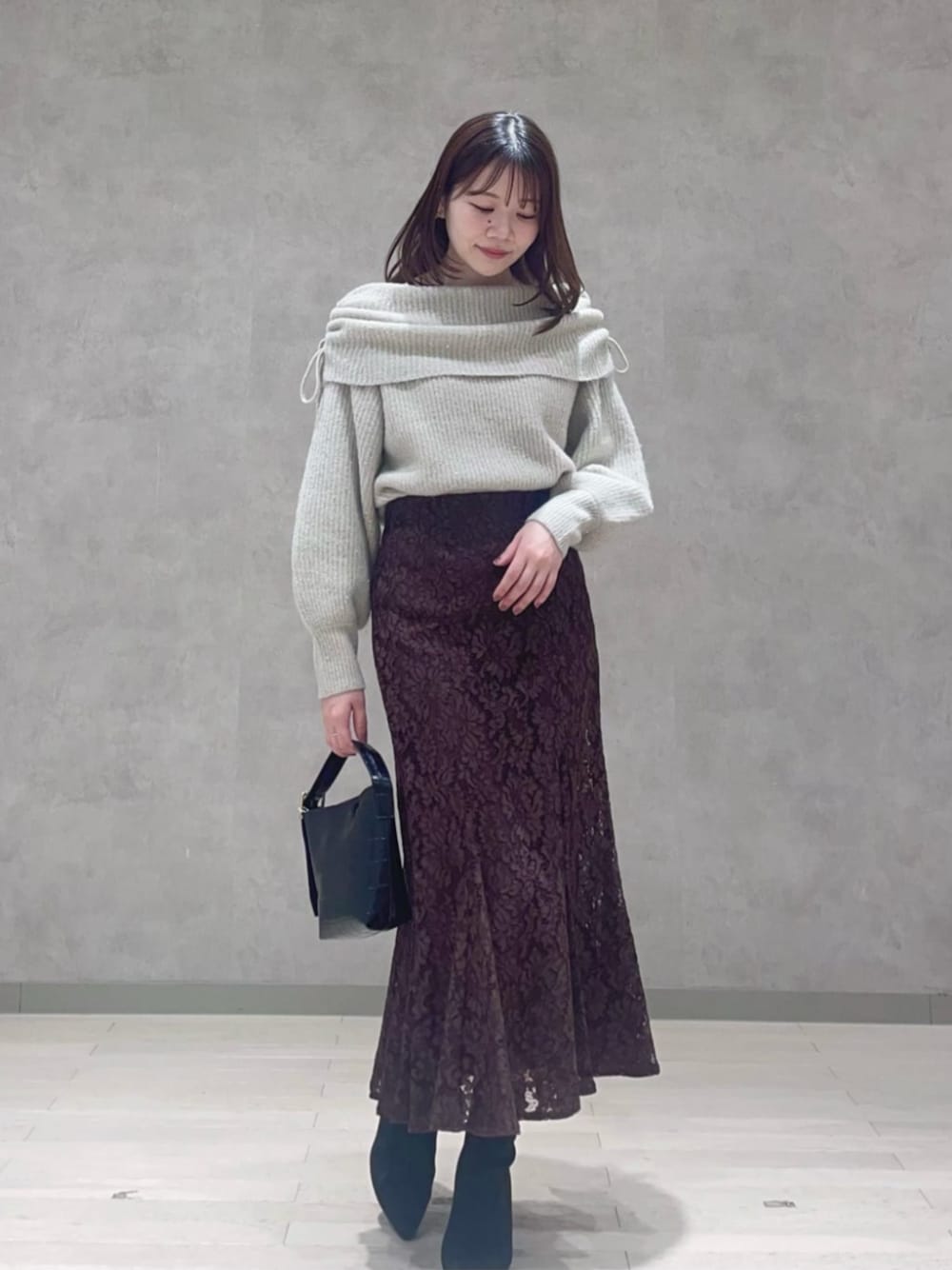 ベージュ系のニット/セーター、ブラウン系のスカートを着用したレディースの冬コーディネートの1枚目の写真