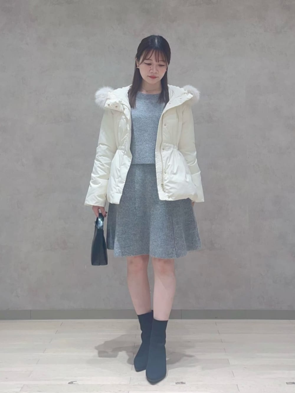 ホワイト系のダウンジャケット/コート、グレー系のワンピースを着用したレディースの冬コーディネートの1枚目の写真