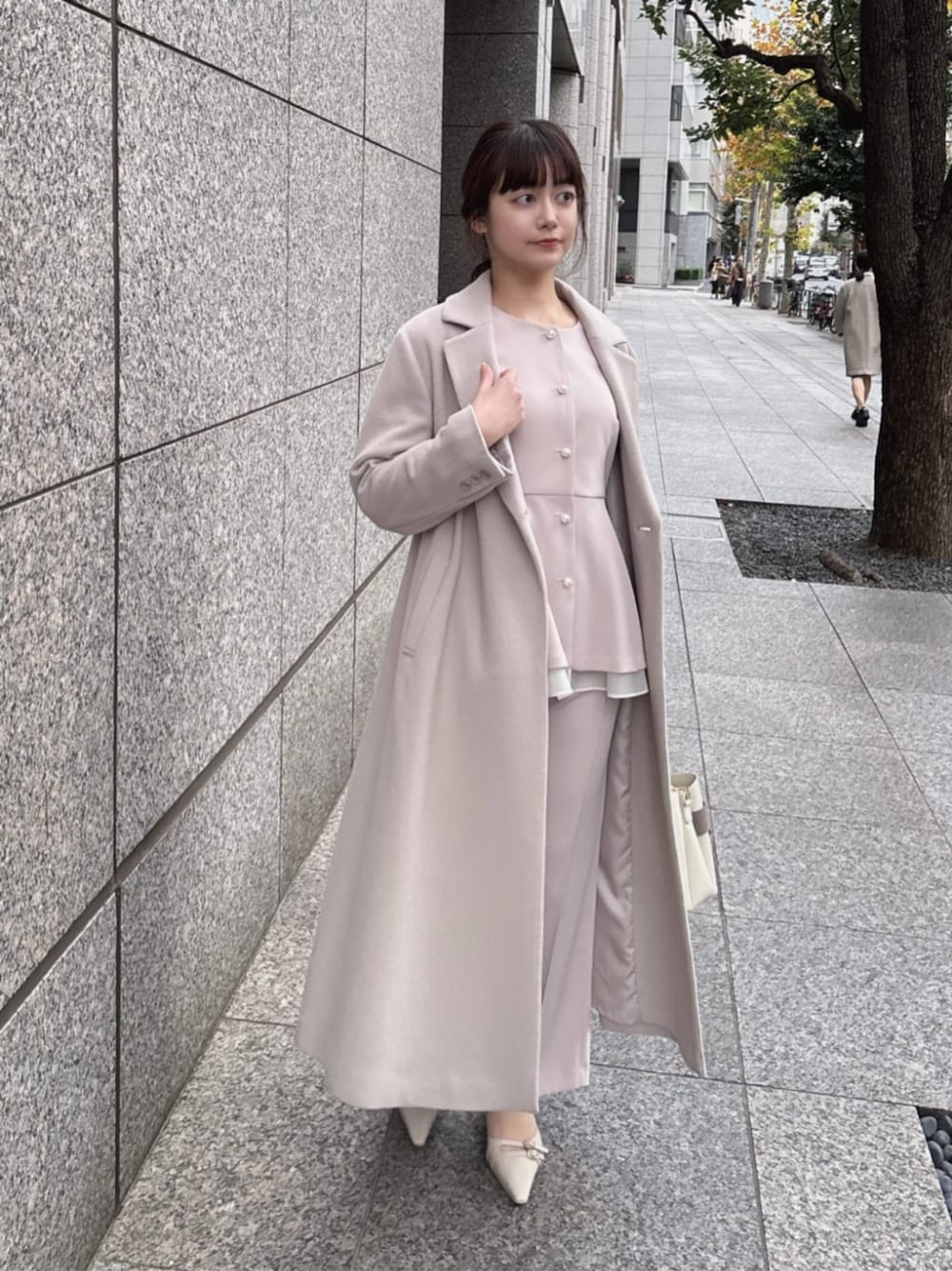 ベージュ系のステンカラーコート、ベージュ系のセットアップ、ベージュ系のその他パンツを着用したレディースの冬コーディネートの1枚目の写真