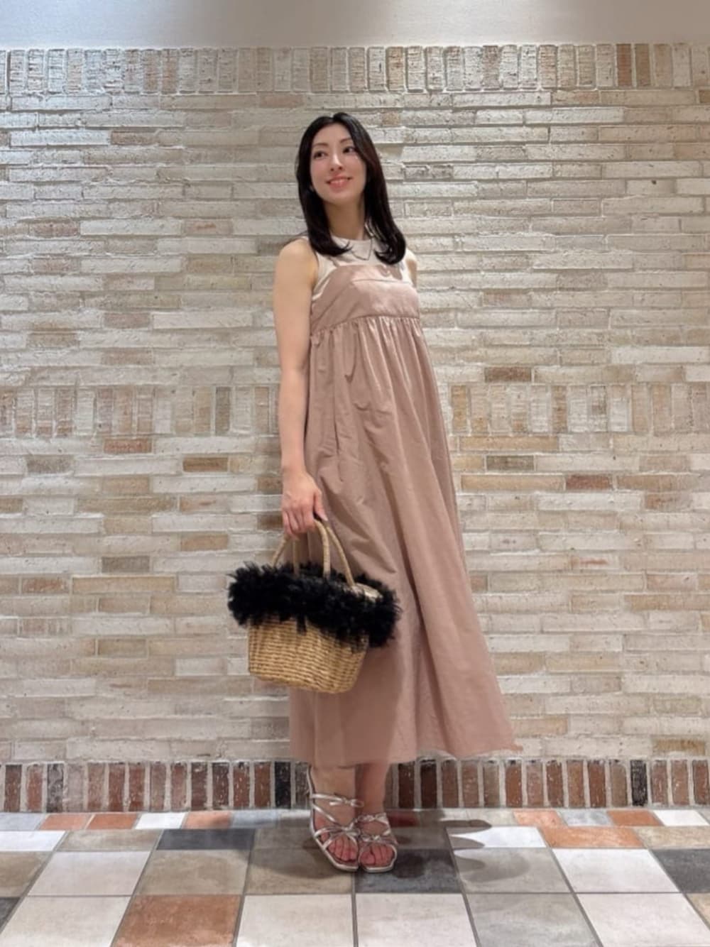 シルバー系のパンプス、ブラック系のショルダーバッグ、ピンク系のワンピースを着用したレディースの夏コーディネートの1枚目の写真