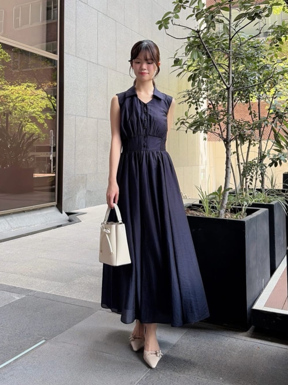 ベージュ系のパンプス、ホワイト系のショルダーバッグ、ブルー系のワンピースを着用したレディースの夏コーディネートの1枚目の写真