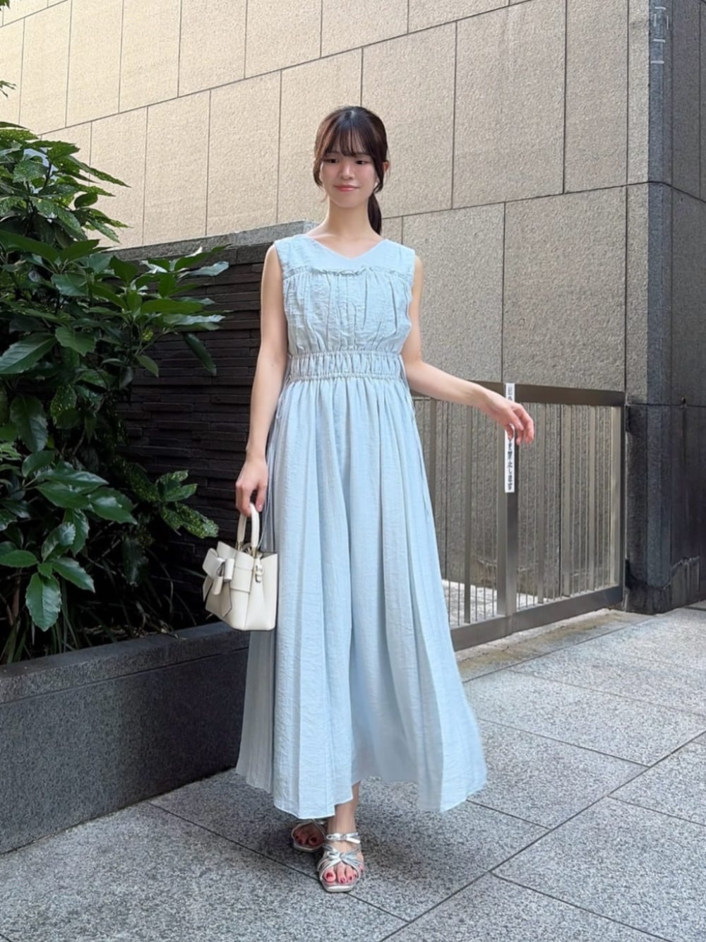 シルバー系のパンプス、ブルー系のワンピース、ホワイト系のショルダーバッグを着用したレディースの夏コーディネートの1枚目の写真