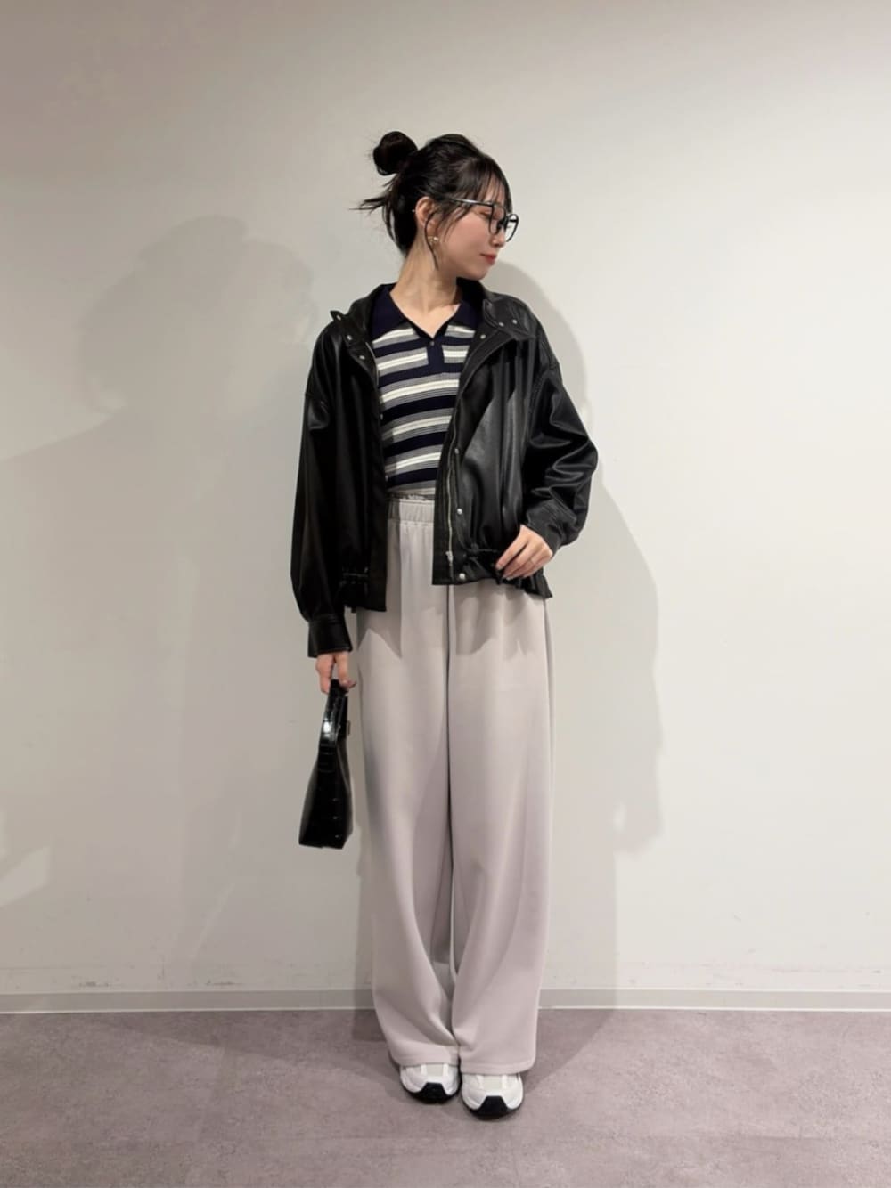 ブラック系のブルゾン、ブルー系のニット/セーター、グレー系のスウェットパンツを着用したレディースの冬コーディネートの1枚目の写真