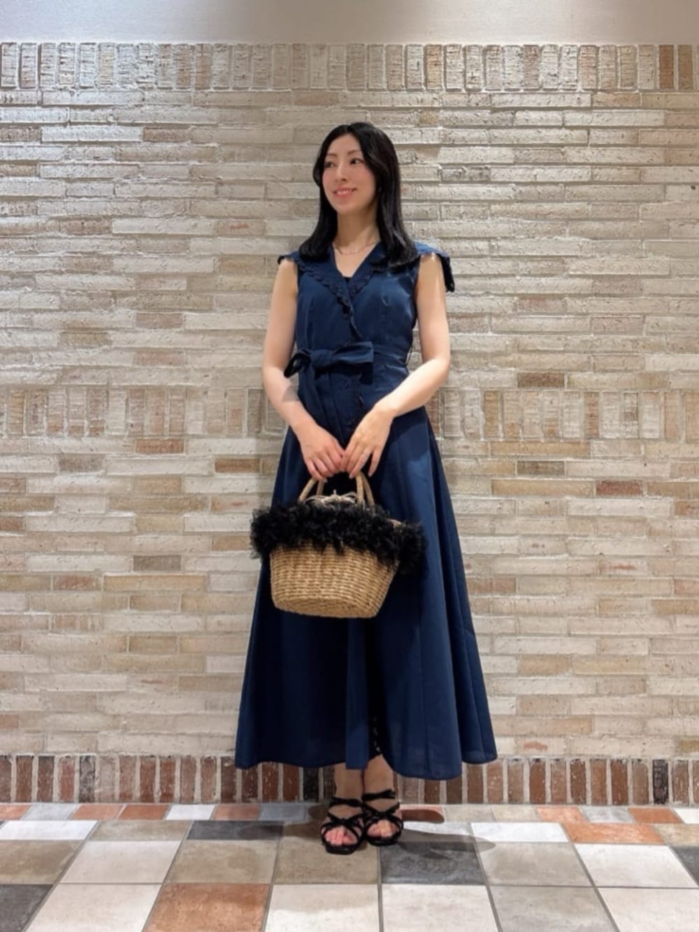 ブラック系のショルダーバッグ、ブラック系のパンプス、ブルー系のワンピースを着用したレディースの夏コーディネートの1枚目の写真