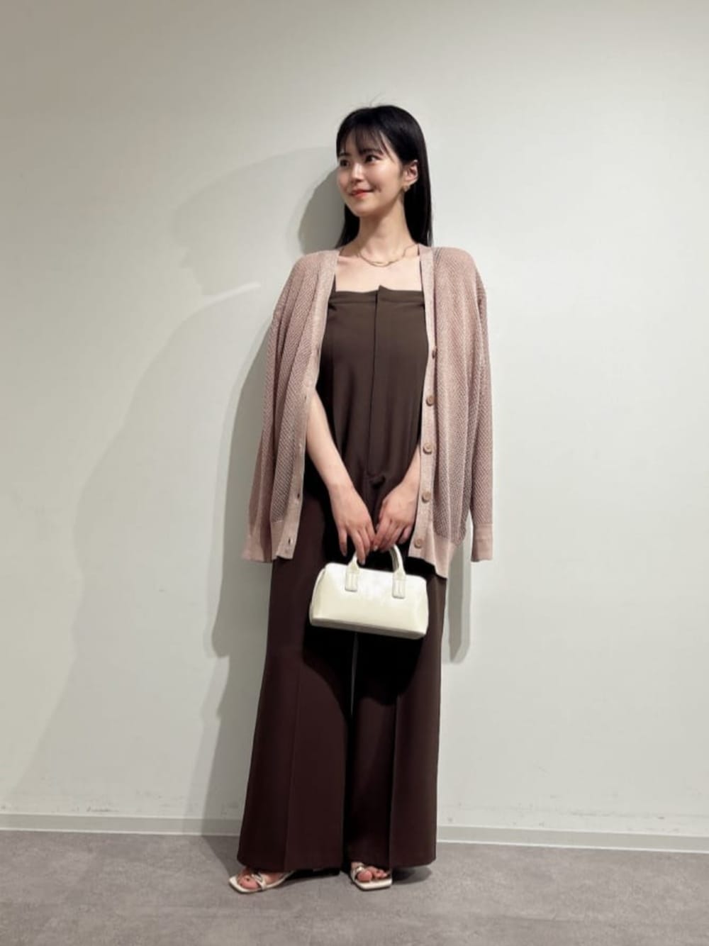 ホワイト系のパンプス、ホワイト系のトートバッグ、ピンク系のニット/セーターを着用したレディースの夏コーディネートの1枚目の写真