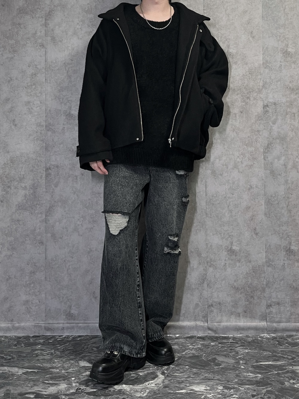 ブラック系のブルゾン、ブラック系のニット/セーター、ブラック系のデニムパンツを着用したメンズの冬コーディネートの1枚目の写真