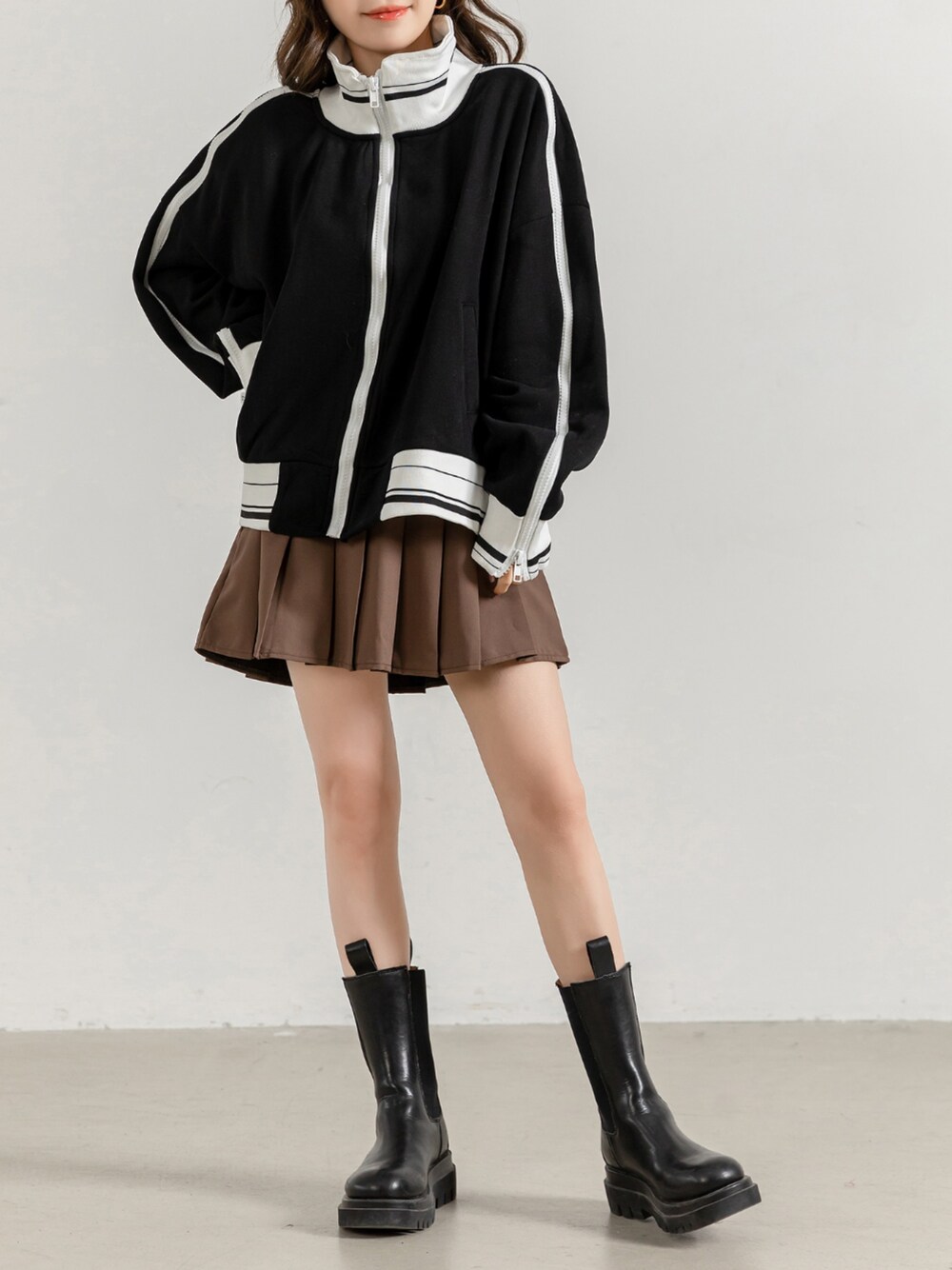 ブラック系のスウェット、ブラウン系のスカートを着用したレディースの春コーディネートの1枚目の写真