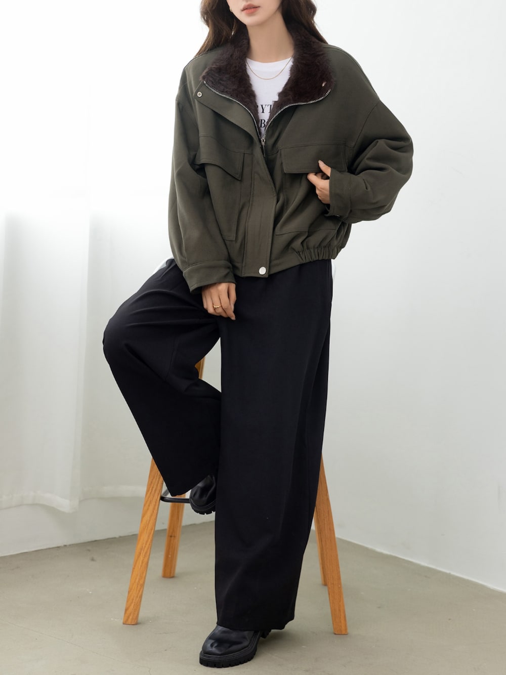 グリーン系のブルゾンを着用したレディースの秋コーディネートの1枚目の写真