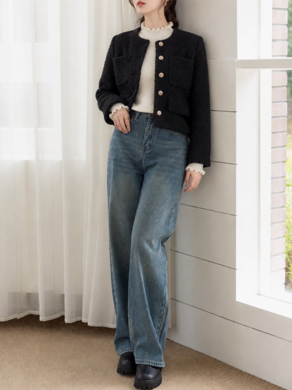 ブラック系のノーカラージャケット、ブルー系のデニムパンツ、ホワイト系のニット/セーターを着用したレディースの秋コーディネートの1枚目の写真