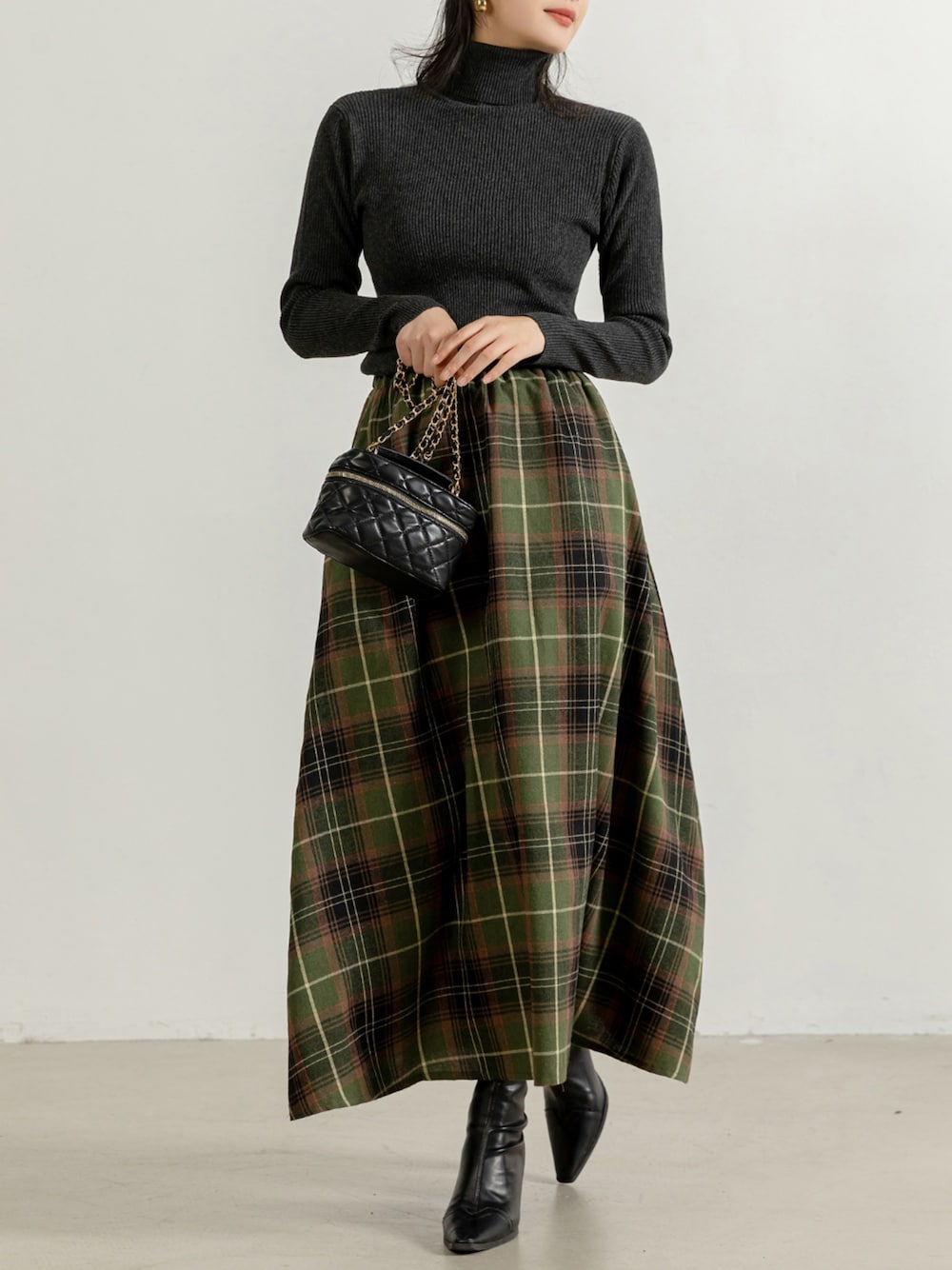 グリーン系のスカート、グレー系のニット/セーターを着用したレディースの秋コーディネートの1枚目の写真