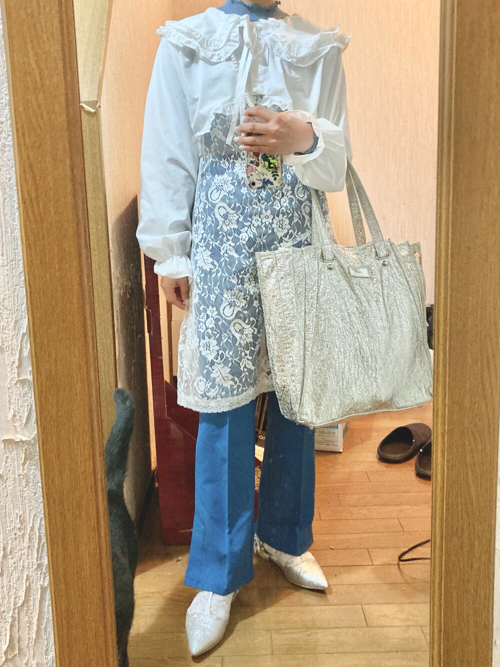 シルバー系のトートバッグ、ブルー系のスラックス、シルバー系のサンダルを着用したレディースの春コーディネートの1枚目の写真