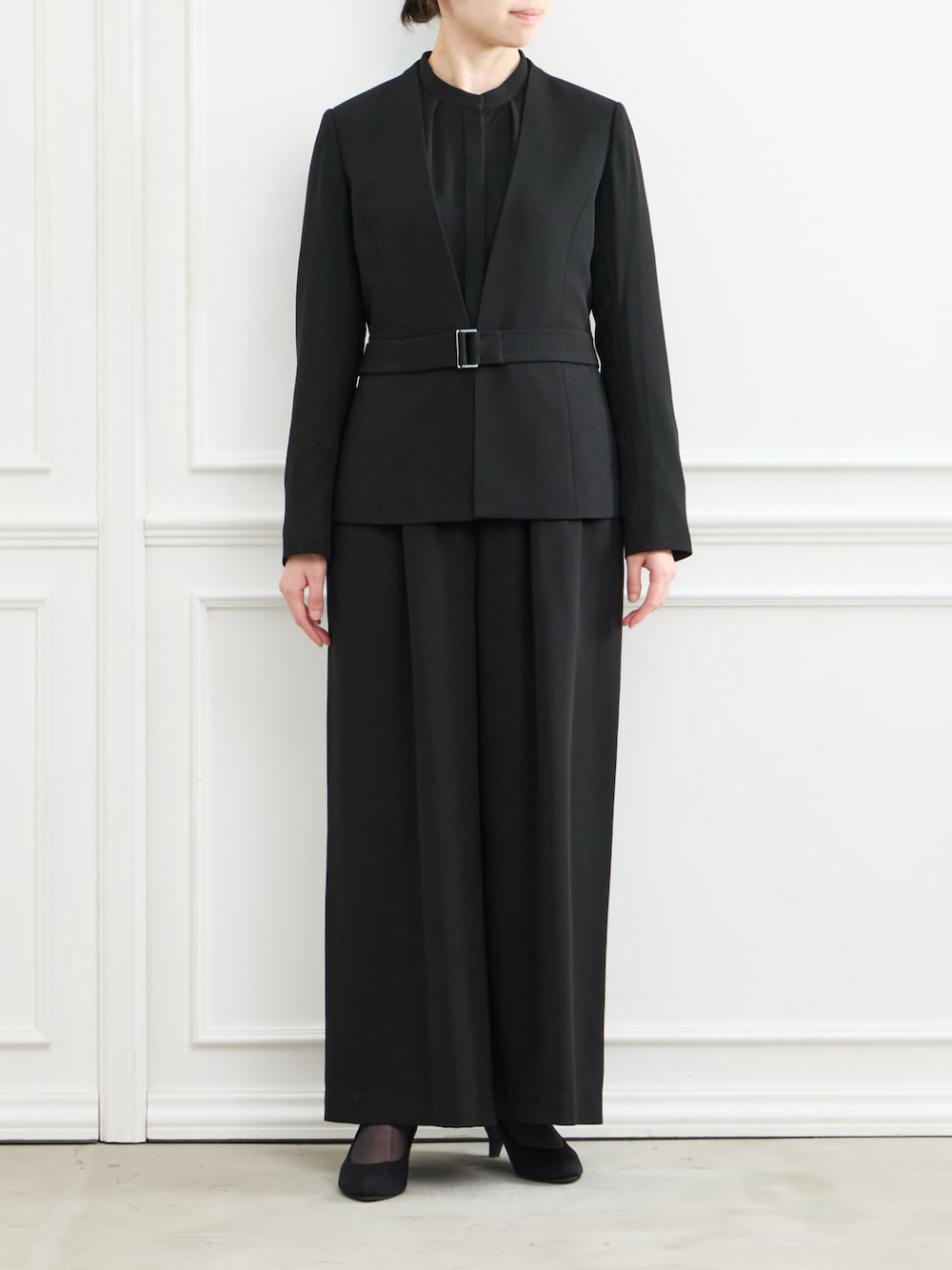 ブラック系のスーツパンツ、ブラック系のパンプスを着用したレディースの冬コーディネートの1枚目の写真