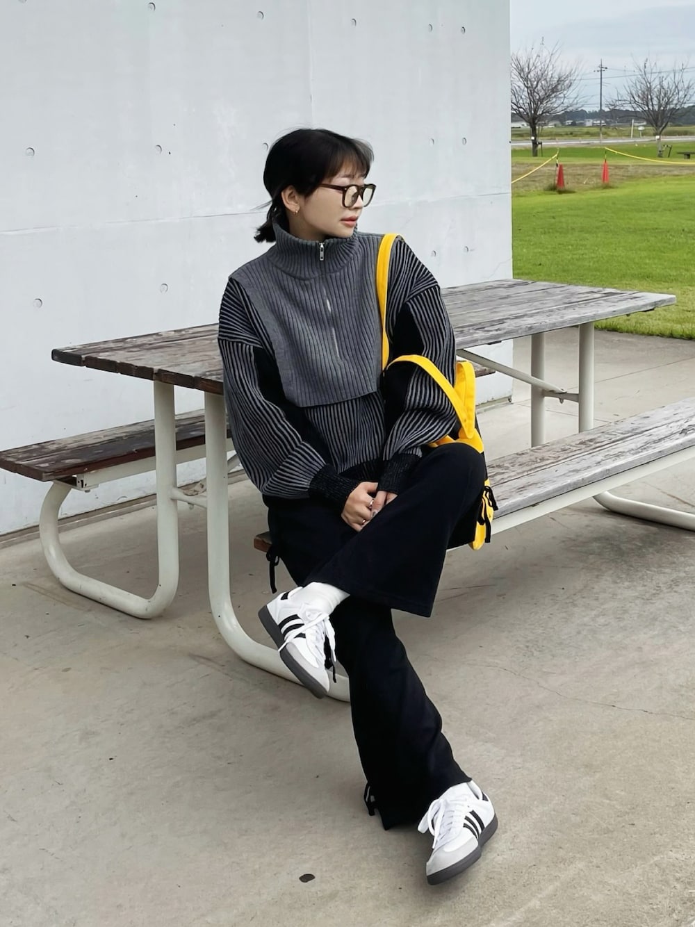 ブラック系のニット/セーター、ホワイト系のスニーカーを着用したレディースの秋コーディネートの1枚目の写真