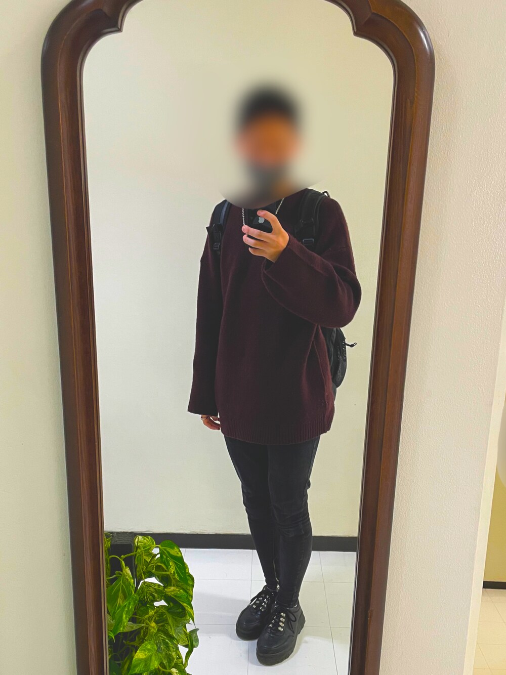 ブラック系のデニムパンツ、レッド系のニット/セーター、ブラック系のスニーカーを着用したメンズの秋コーディネートの1枚目の写真