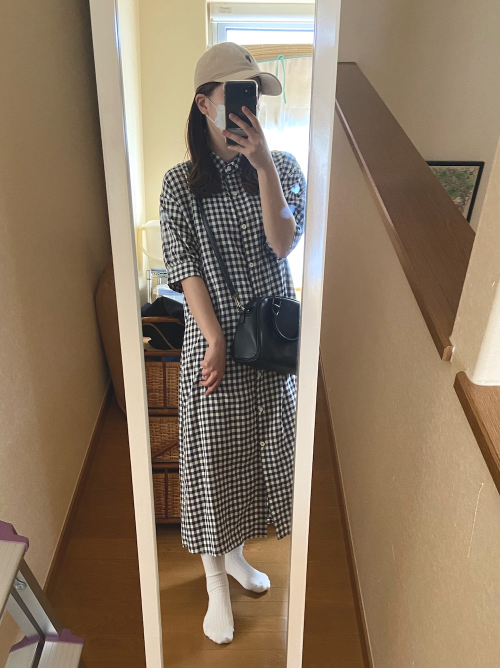 ブラック系のワンピース、ブラック系のショルダーバッグ、グリーン系のキャップを着用したレディースの夏コーディネートの1枚目の写真