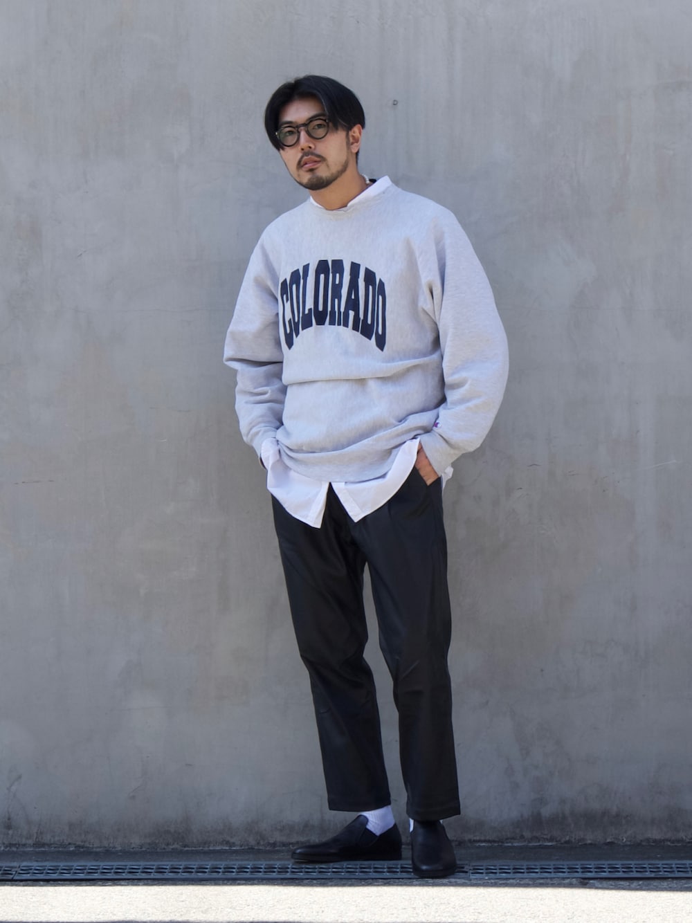 「春服デビュー宣言、春コーデ、レザーパンツ、スウェット、ロゴスウェット、カレッジロゴ、レイヤードスタイル、メガネ男子、スリッポン、革靴、オトナカジュアル、きれいめカジュアル、シンプルコーデ、モノトーン」｜「alfredoBANNISTERの【定番木型】サイドゴア レザースリッポン（スリッポン、ブラック系）」を使った、明賀健太さん（メンズ・178cm）の春コーディネートの1枚目の写真