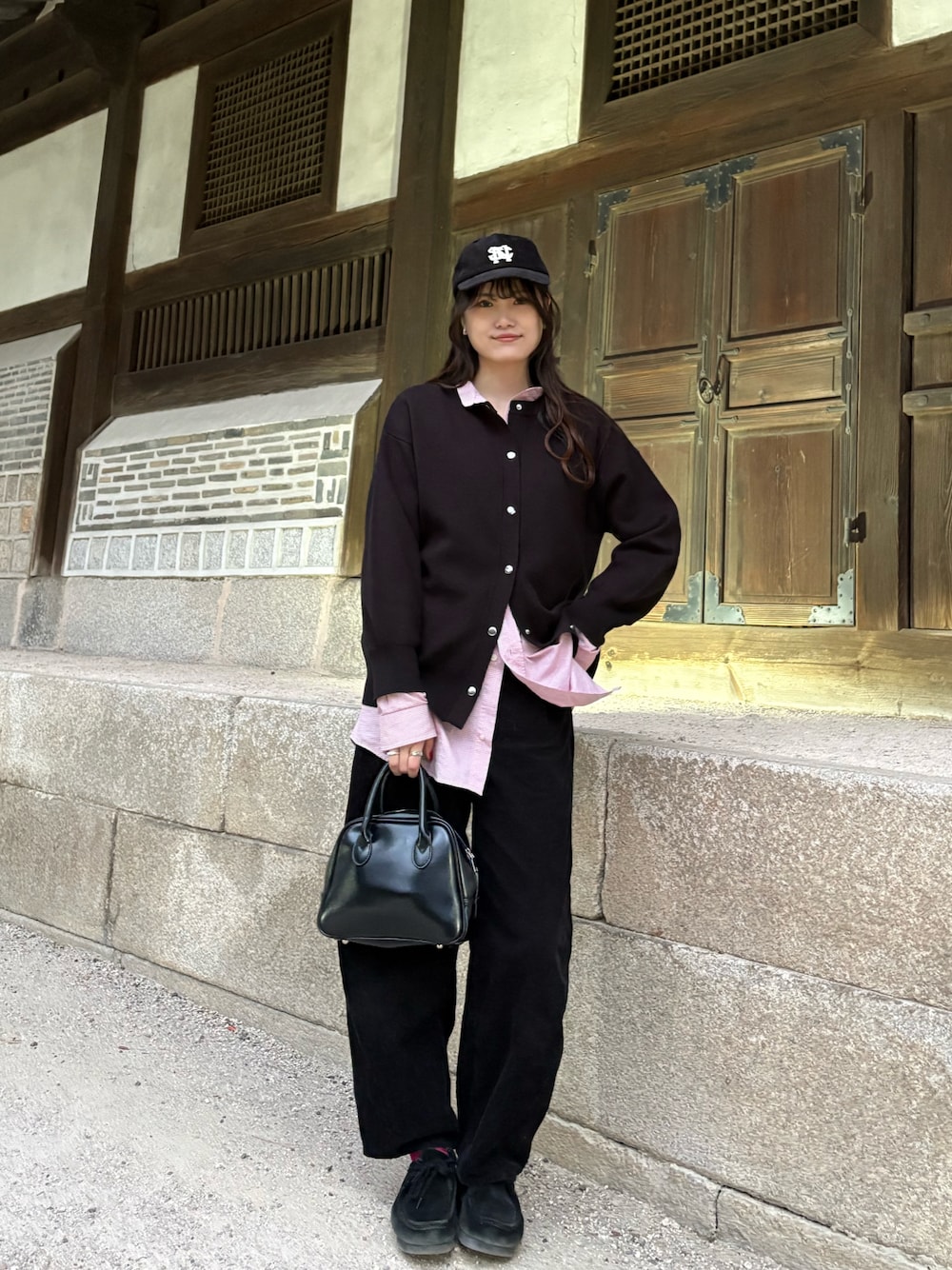 ブラック系のモカシン/デッキシューズ、ブラック系のキャップを着用したレディースの秋コーディネートの1枚目の写真