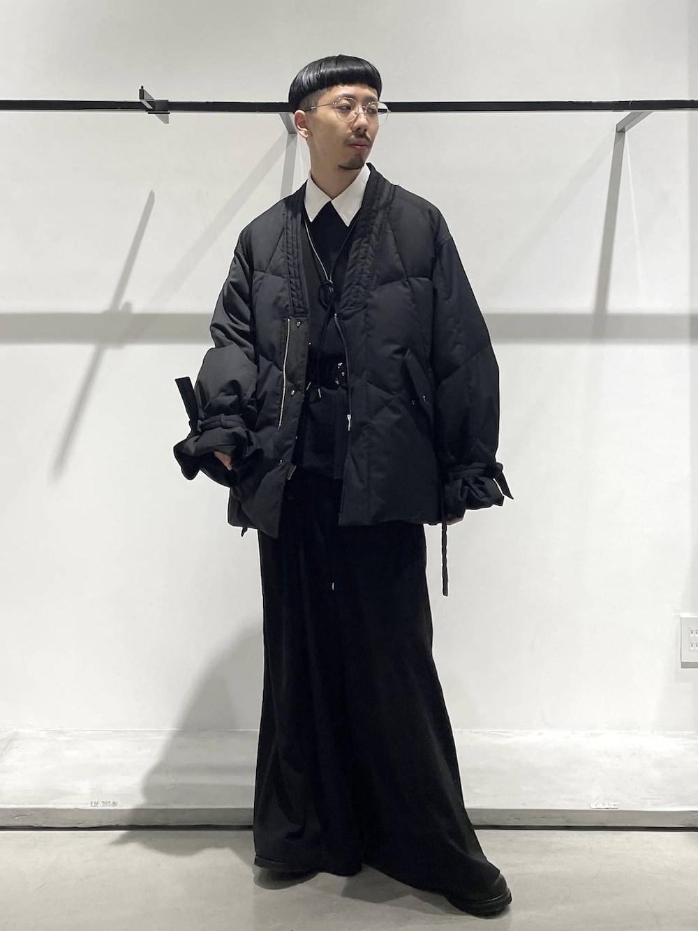 ブラック系のスラックス、ブラック系のローファー、ブラック系のボディバッグ/ウエストポーチを着用したメンズの冬コーディネートの1枚目の写真