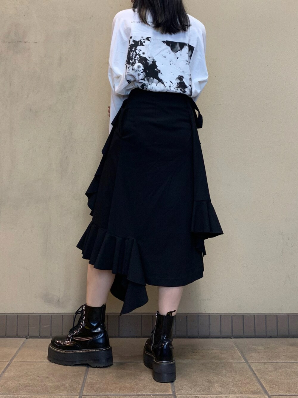 その他のTシャツ/カットソー、ブラック系のスカート、ブラック系のブーツを着用したレディースの秋コーディネートの1枚目の写真