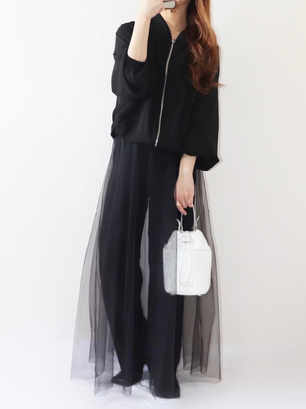 ブラック系のスカート、ブラック系のブルゾン、ゴールド系のリングを着用したレディースの春コーディネートの1枚目の写真