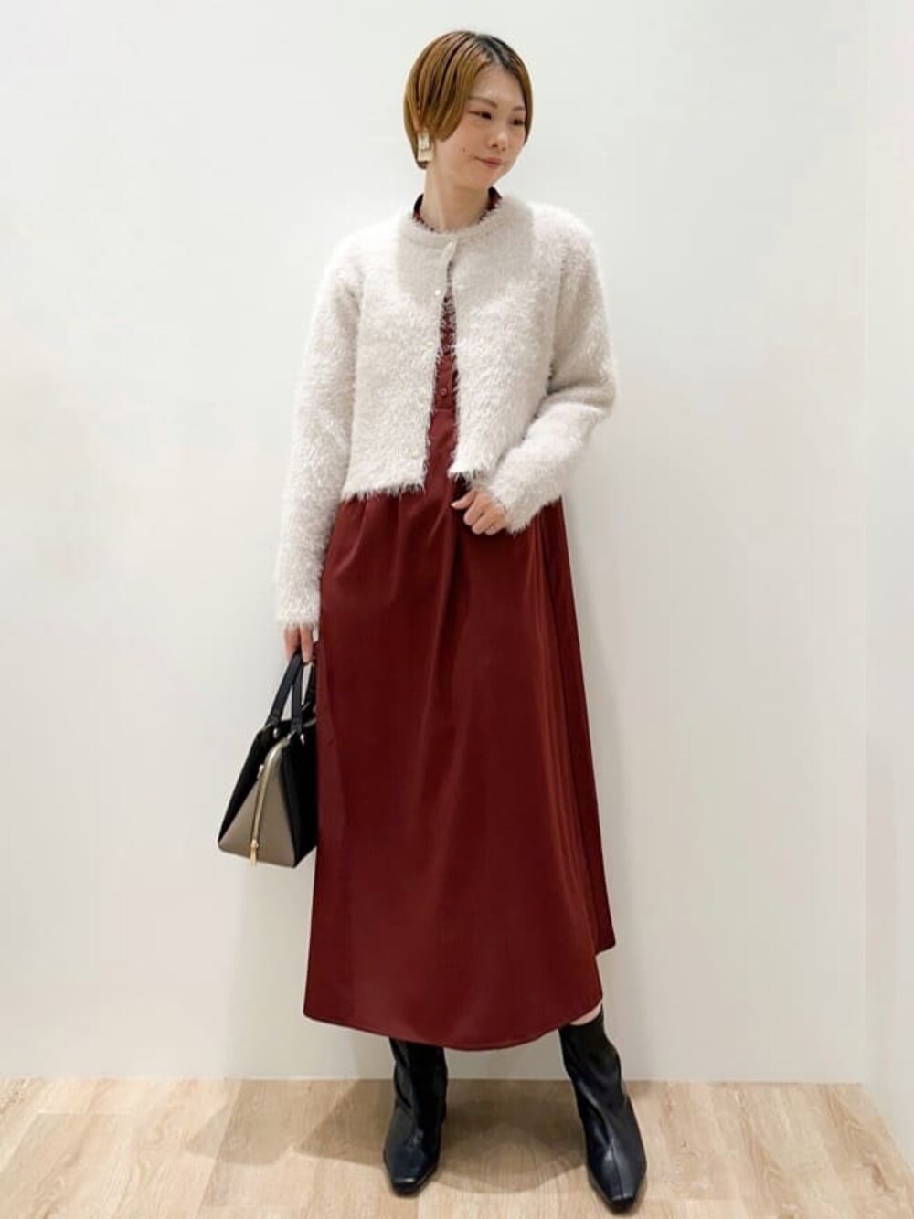 ホワイト系のカーディガン/ボレロ、レッド系のワンピース、ブラック系のショルダーバッグを着用したレディースの秋コーディネートの1枚目の写真