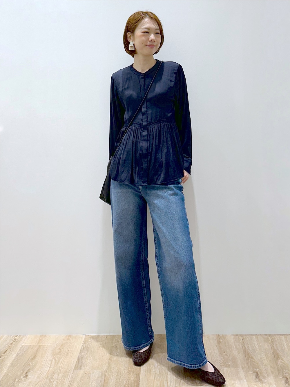 ブルー系のシャツ/ブラウス、ブルー系のデニムパンツ、ブラック系のショルダーバッグを着用したレディースの秋コーディネートの1枚目の写真
