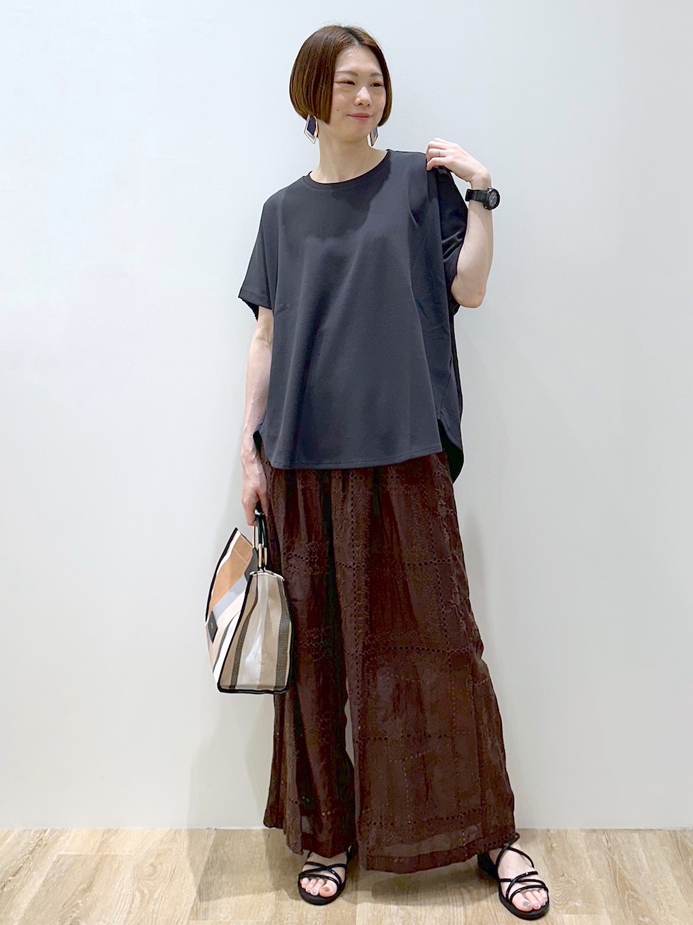 グレー系のTシャツ/カットソー、ブラウン系のその他パンツ、ブラック系のトートバッグを着用したレディースの春コーディネートの1枚目の写真