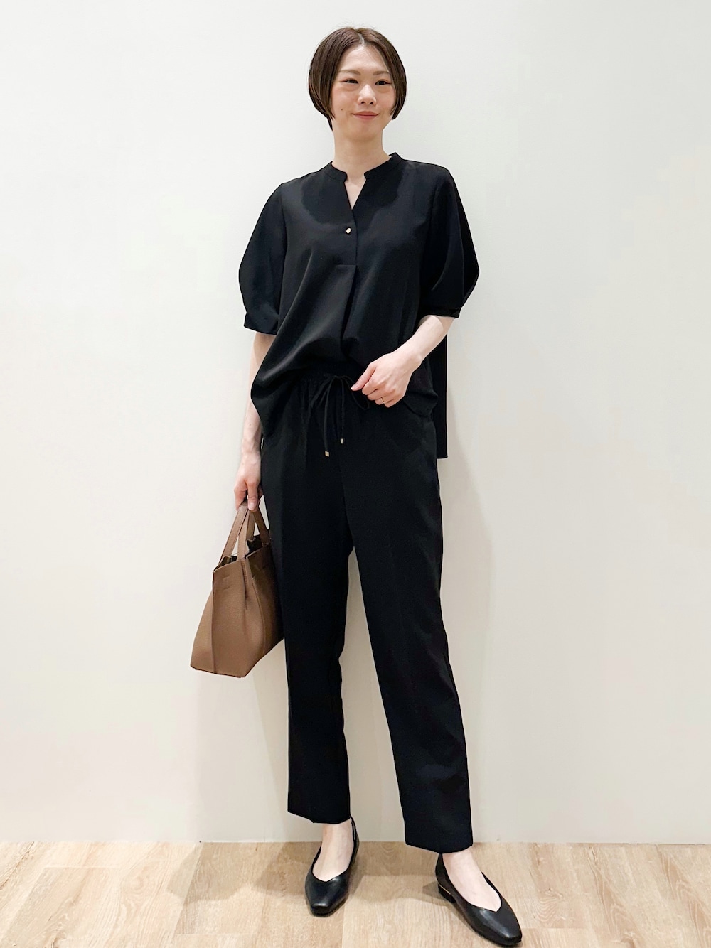 ブラック系のパンプス、ブラック系のシャツ/ブラウス、ブラック系のその他パンツを着用したレディースの春コーディネートの1枚目の写真