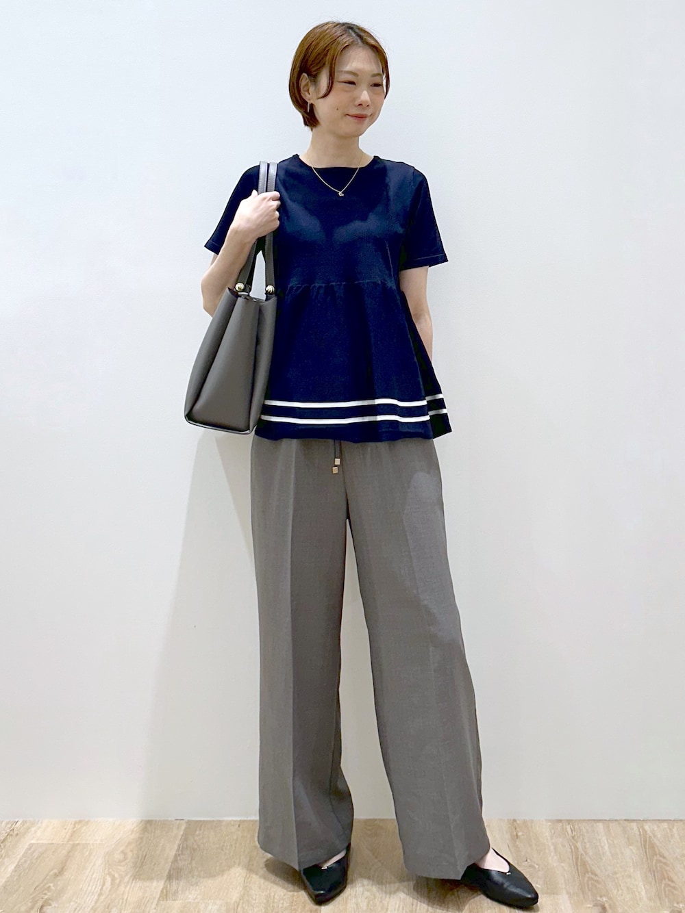 ブルー系のニット/セーター、グレー系のその他パンツ、グレー系のトートバッグを着用したレディースの夏コーディネートの1枚目の写真