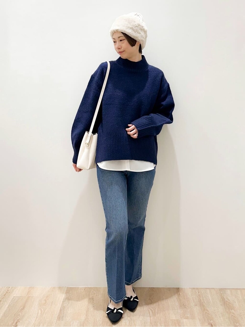 ブルー系のニット/セーター、ホワイト系のTシャツ/カットソー、ブルー系のデニムパンツを着用したレディースの冬コーディネートの1枚目の写真