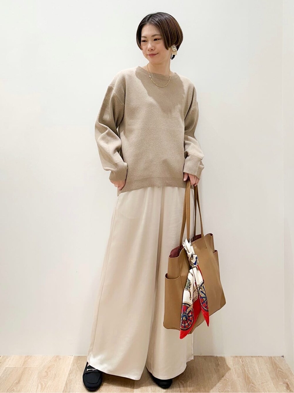 ベージュ系のニット/セーター、ホワイト系のその他パンツ、ベージュ系のトートバッグを着用したレディースの冬コーディネートの1枚目の写真