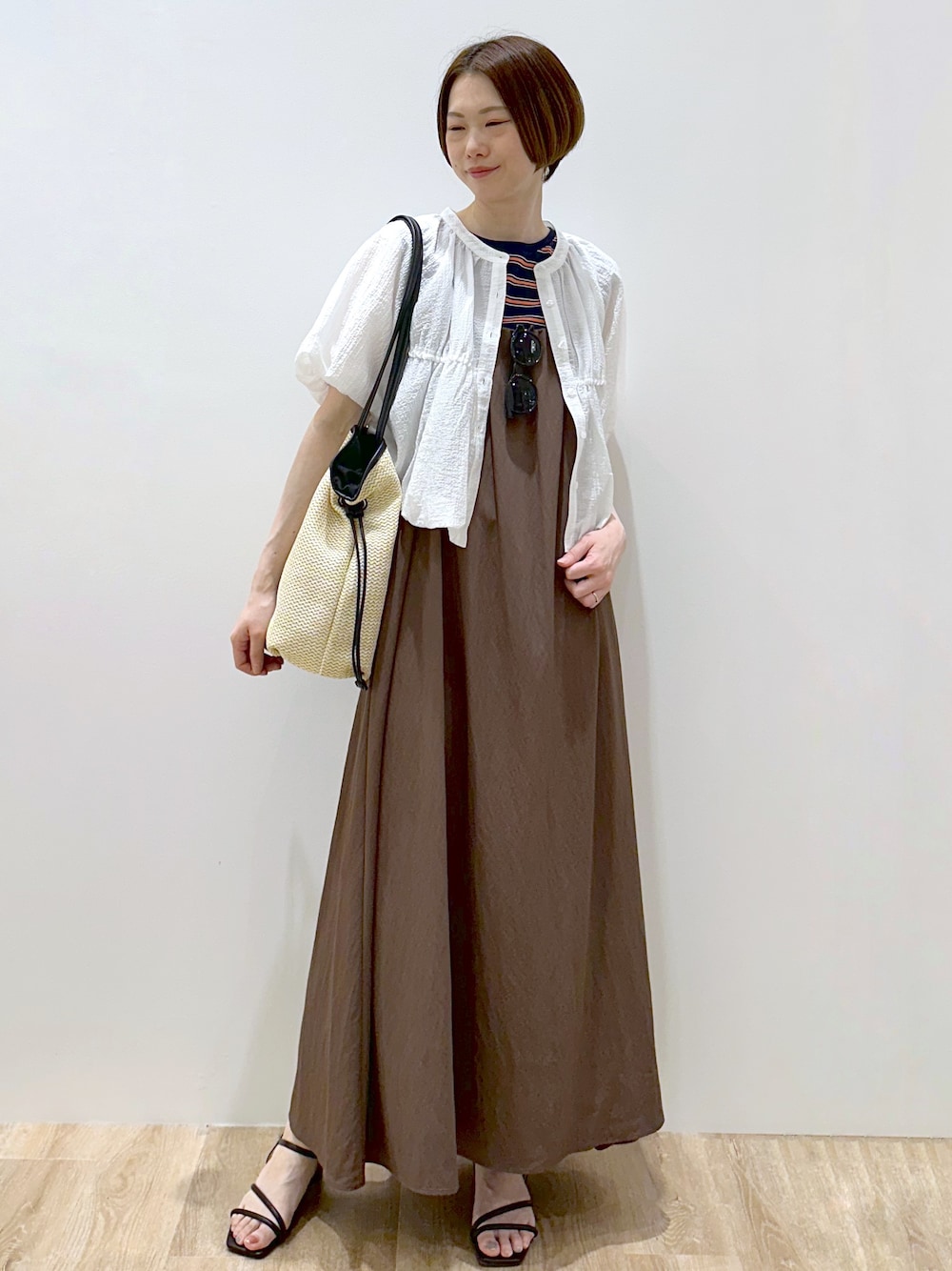 ブルー系のTシャツ/カットソー、ブラウン系のワンピース、ホワイト系のトートバッグを着用したレディースの春コーディネートの1枚目の写真