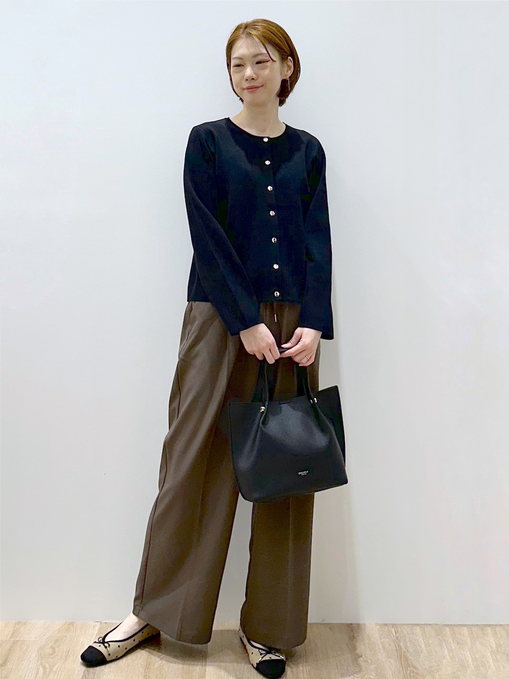 ブラック系のカーディガン/ボレロ、ブラウン系のその他パンツ、ブラック系のショルダーバッグを着用したレディースの秋コーディネートの1枚目の写真