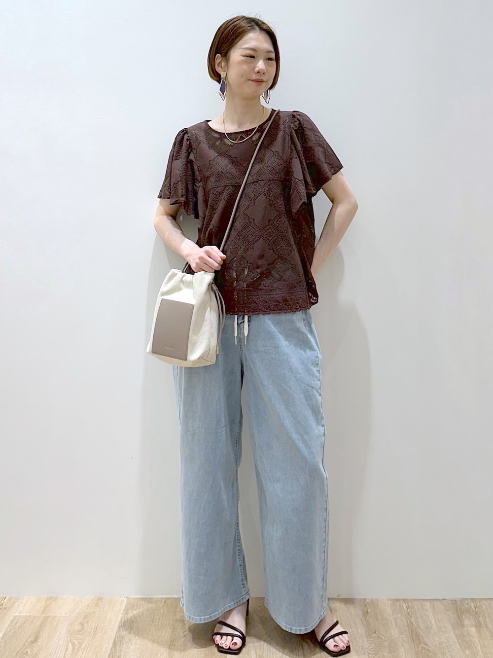 ブラウン系のシャツ/ブラウス、ブルー系のデニムパンツ、ブラック系のサンダルを着用したレディースの春コーディネートの1枚目の写真