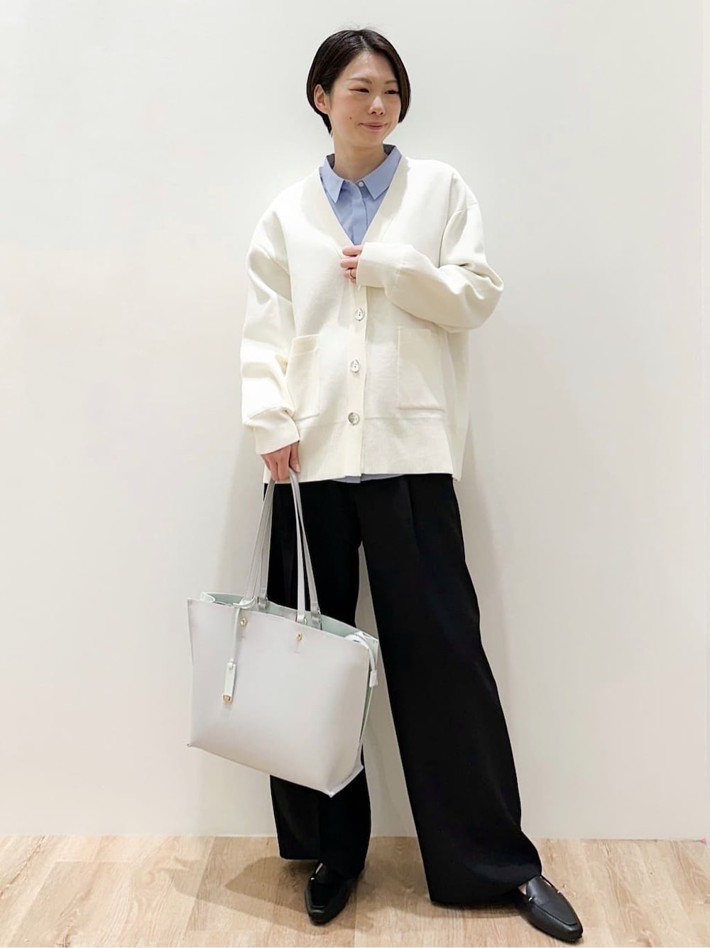グレー系のトートバッグ、ブルー系のシャツ/ブラウス、ブラック系のその他パンツを着用したレディースの春コーディネートの1枚目の写真