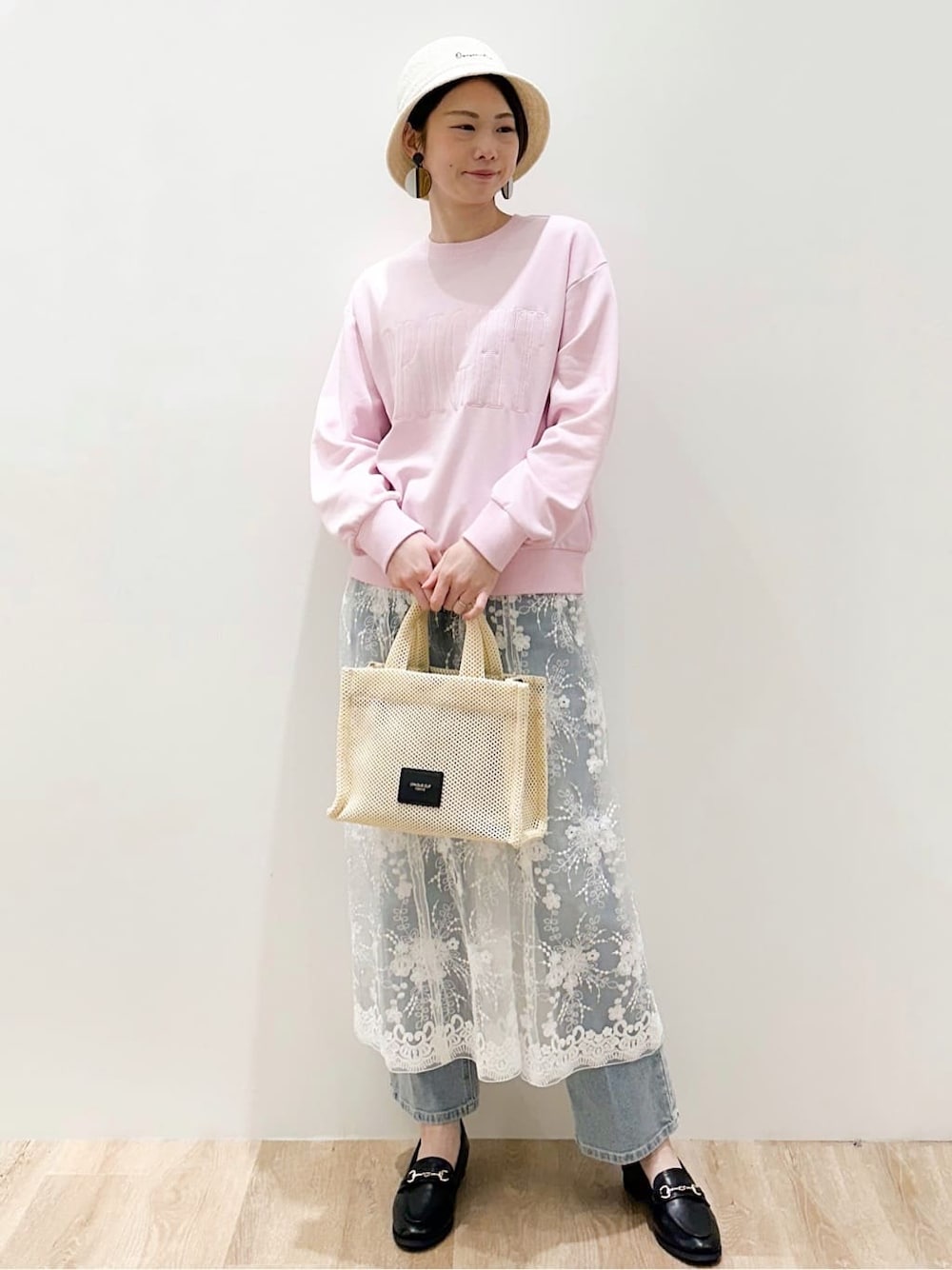 ブラック系のパンプス、ブルー系のデニムパンツ、ピンク系のTシャツ/カットソーを着用したレディースの春コーディネートの1枚目の写真