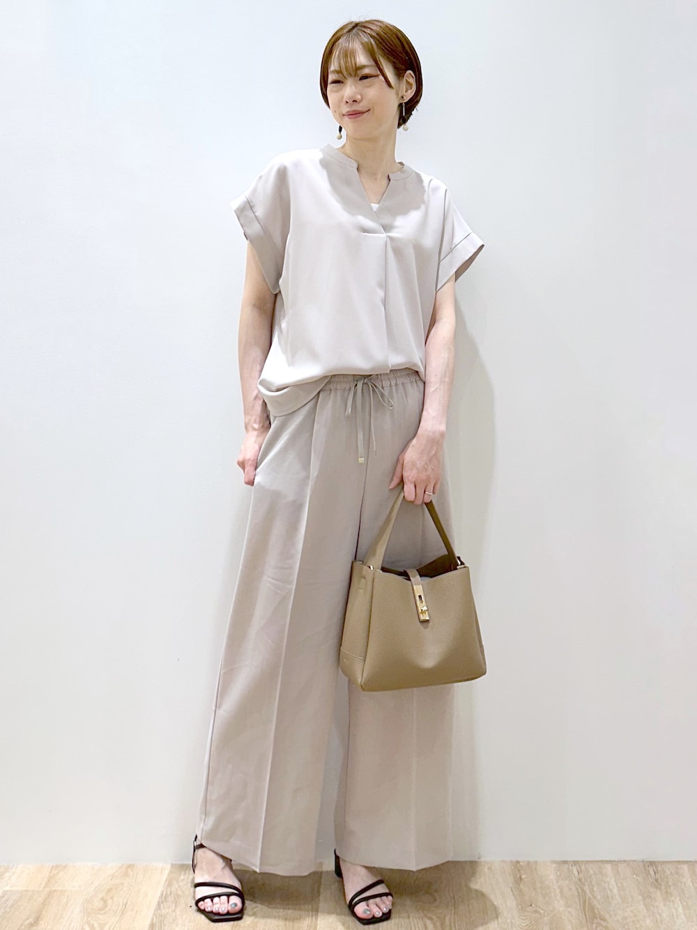 ベージュ系のシャツ/ブラウス、ベージュ系のその他パンツ、ブラウン系のトートバッグを着用したレディースの夏コーディネートの1枚目の写真